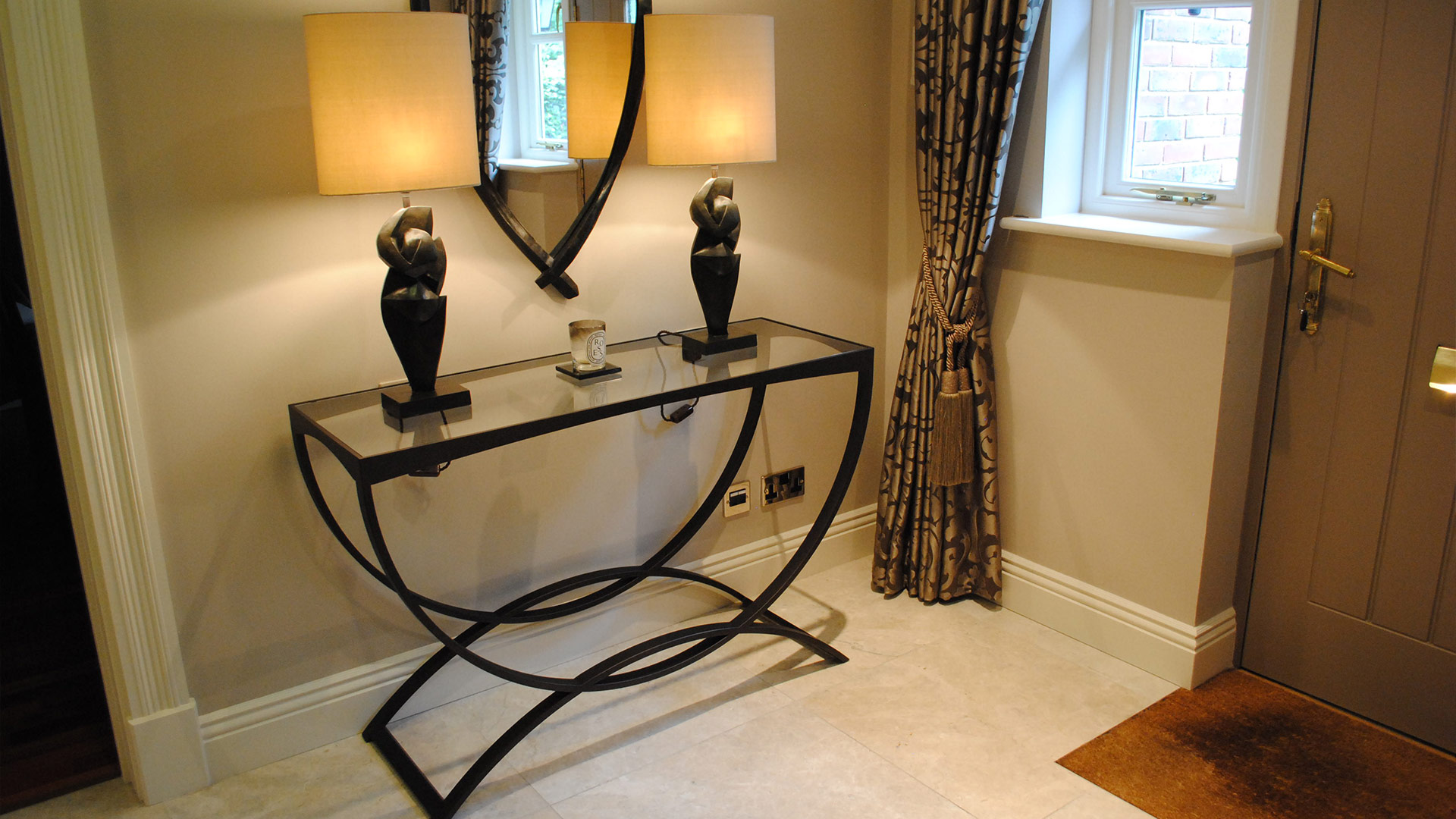 Hallway with Tom Faulkner console table with Porta Romana lamps and Manuel Canovas silk curtains